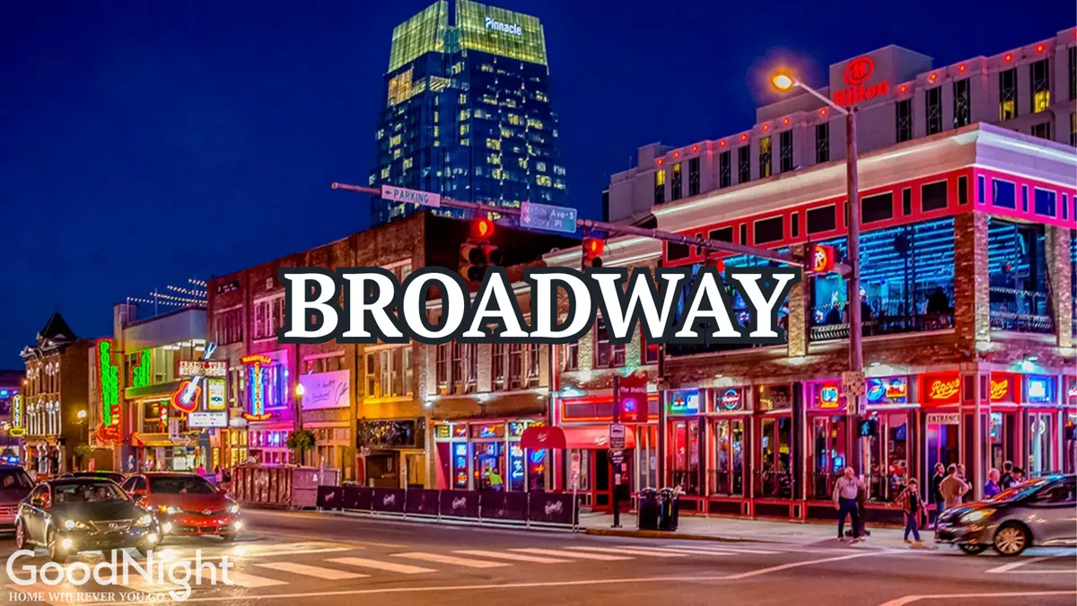 A vibrant nighttime street scene filled with colorful neon signs, bustling crowds, cars cruising down Broadway, and a variety of storefronts alive with energy. People are visible walking and enjoying the nightlife, hinting at music venues and restaurants.